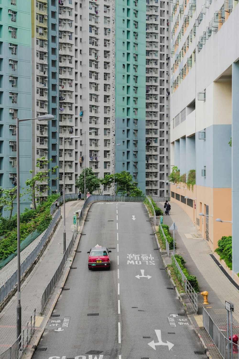 red car travelling on road near buildings