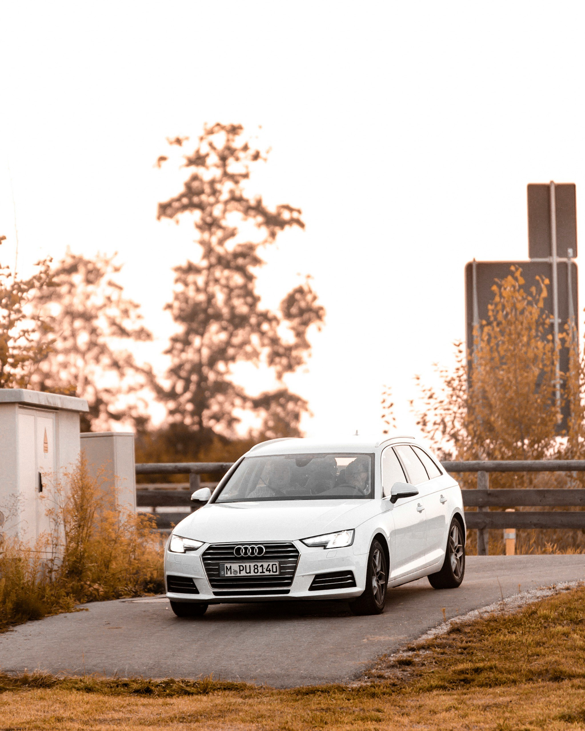 white Audi car on concrete pavement at daytime