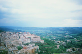 A scenic view of Palencia's countryside with historic buildings and lush greenery under a bright sky.
