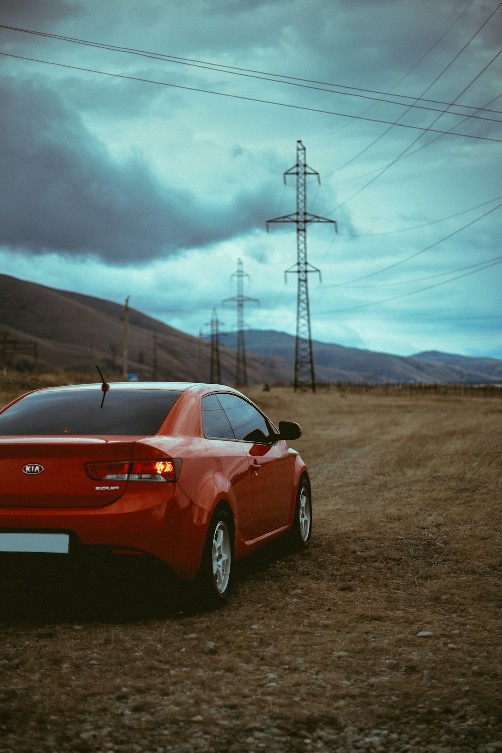 red Hyundai coupe near transmission tower