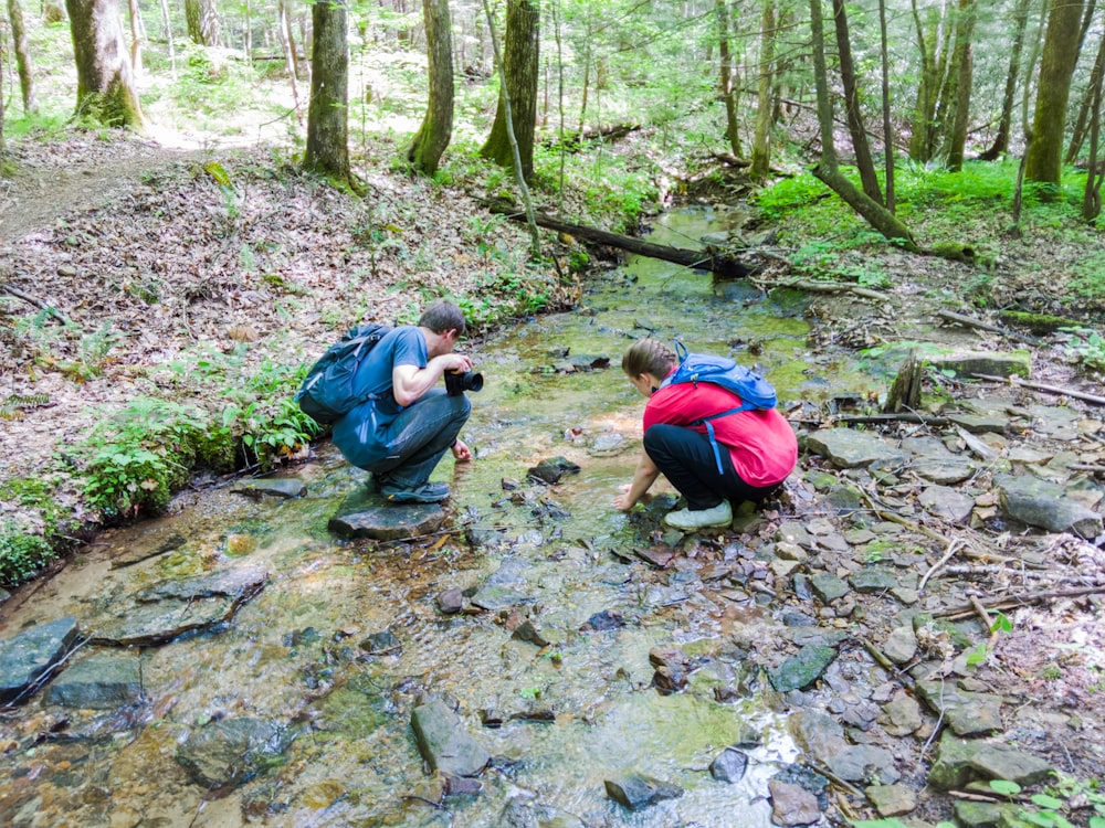 two men washing hands in river