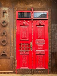 red painted door on brown rustic metal wall