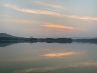A tranquil scene of a quiet lake at dusk, reflecting soft pastel colors.