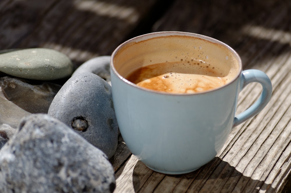 blue ceramic cup filled with coffee