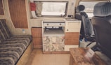 Cozy RV kitchen featuring compact shelves and hanging storage solutions.