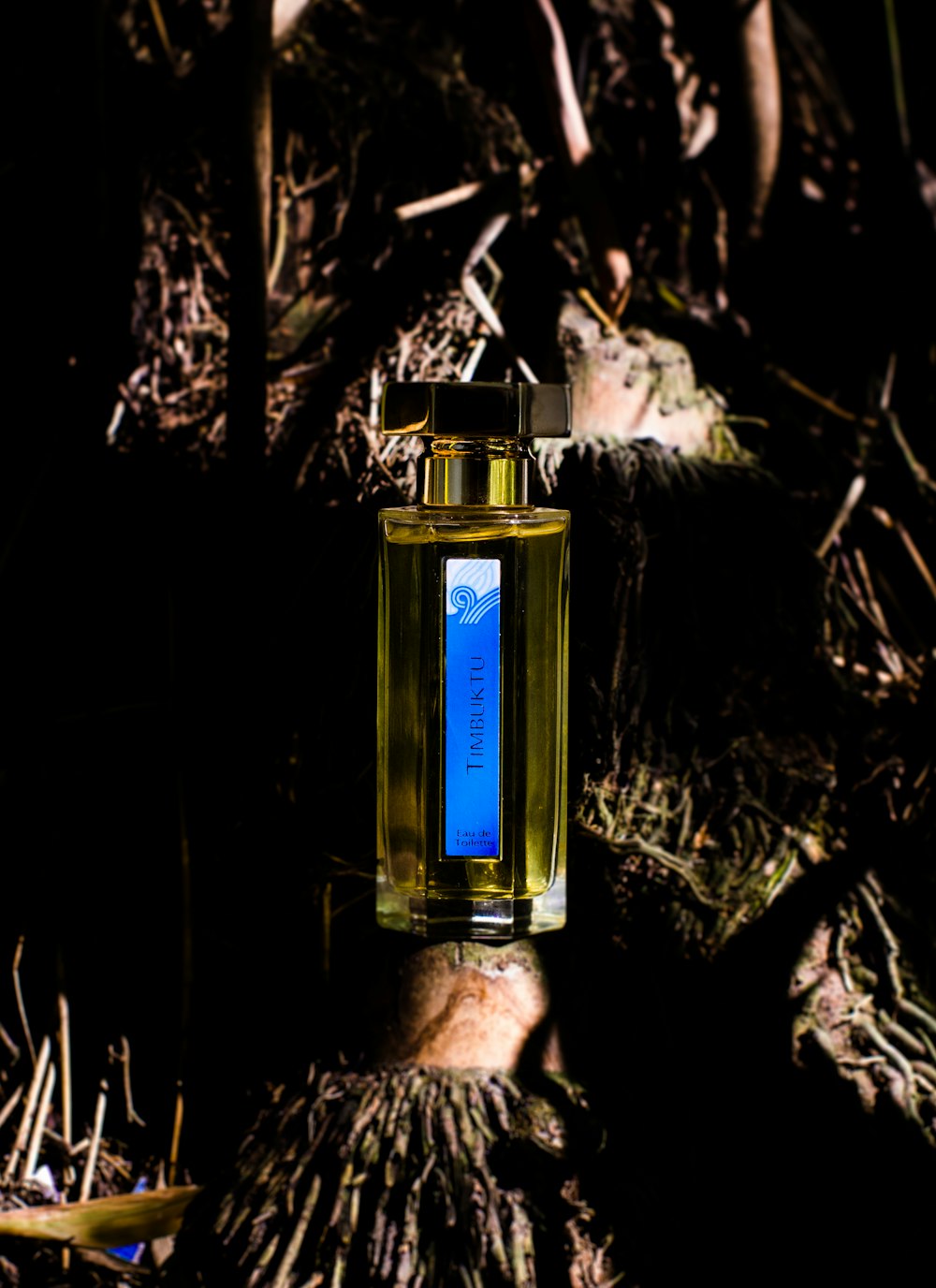 blue scent bottle on bamboo shoot