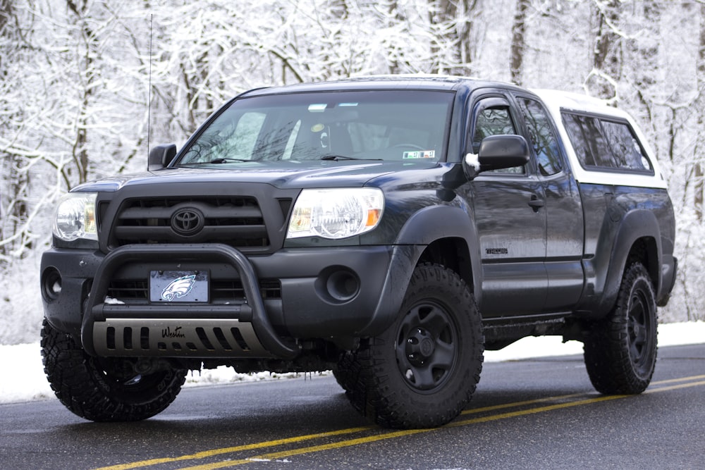 black Toyota extended cab pickup truck with camper shell