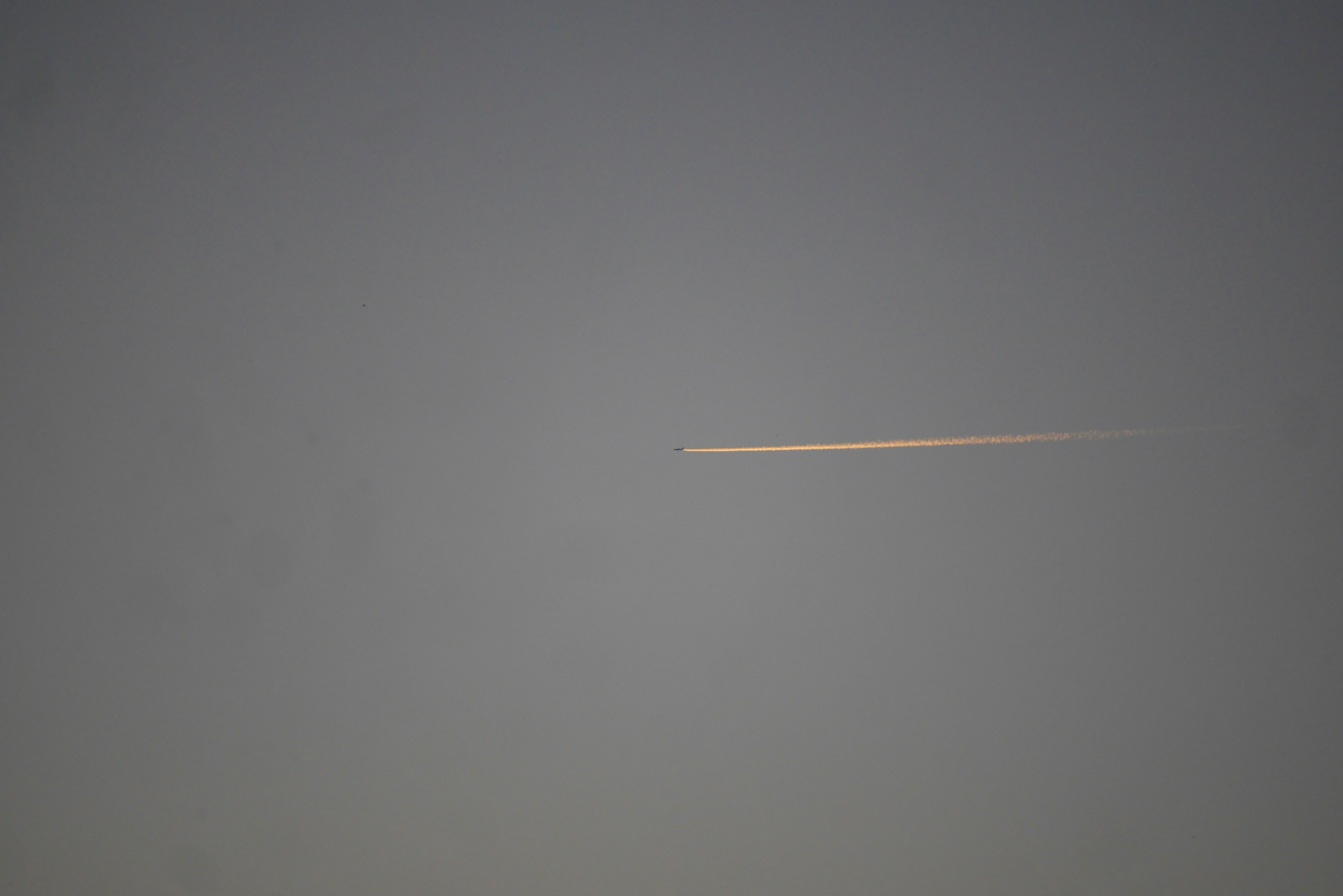 an airplane is flying in the sky with a trail of smoke