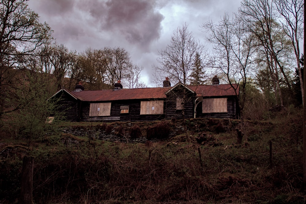 Casa marrom de 1 andar cercada por árvores