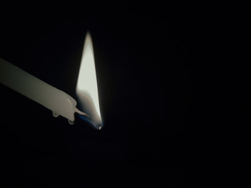 A warm candle flickering softly in a quiet chapel, symbolizing hope and prayer.