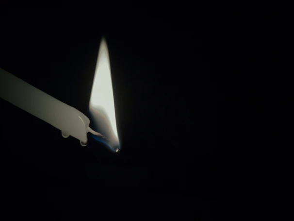 A candle burning softly in a dark room, symbolizing hope and guidance.