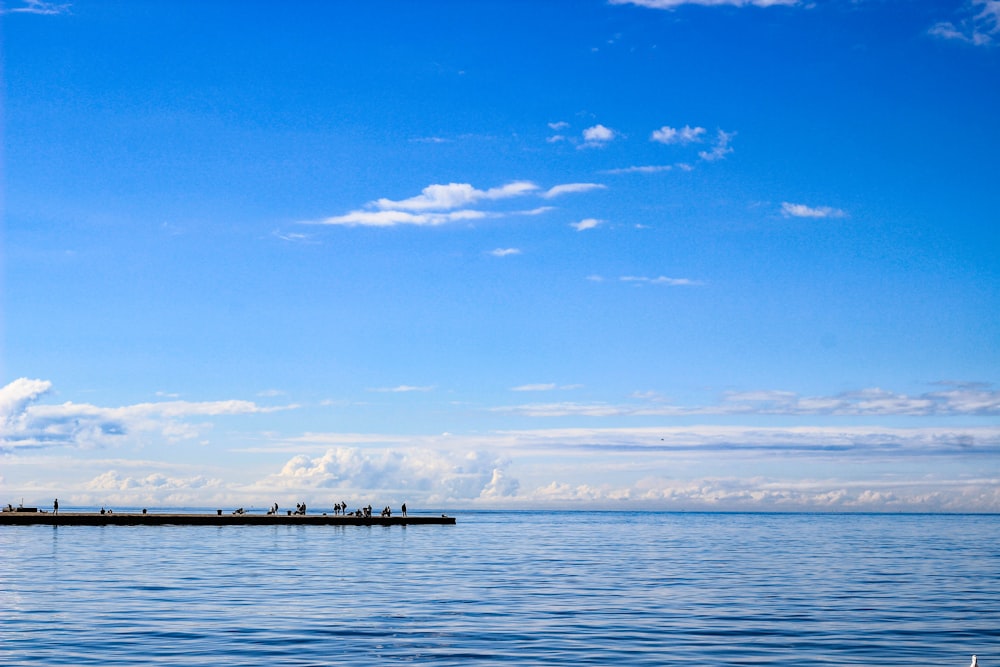 un grande specchio d'acqua con un faro in lontananza