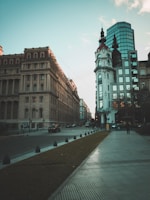 person walking on sidewalk beside road way and building