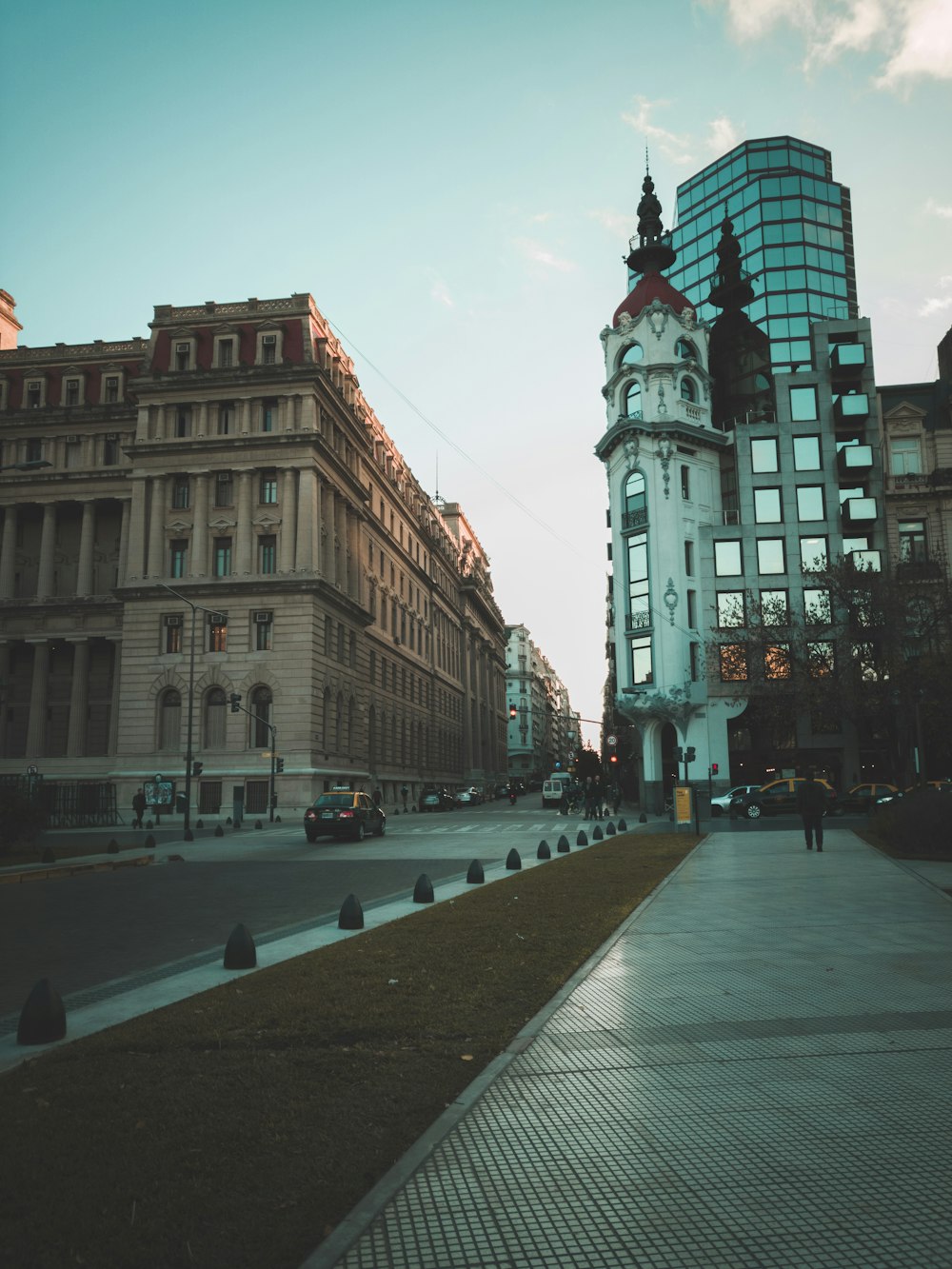 person walking on sidewalk beside road way and building