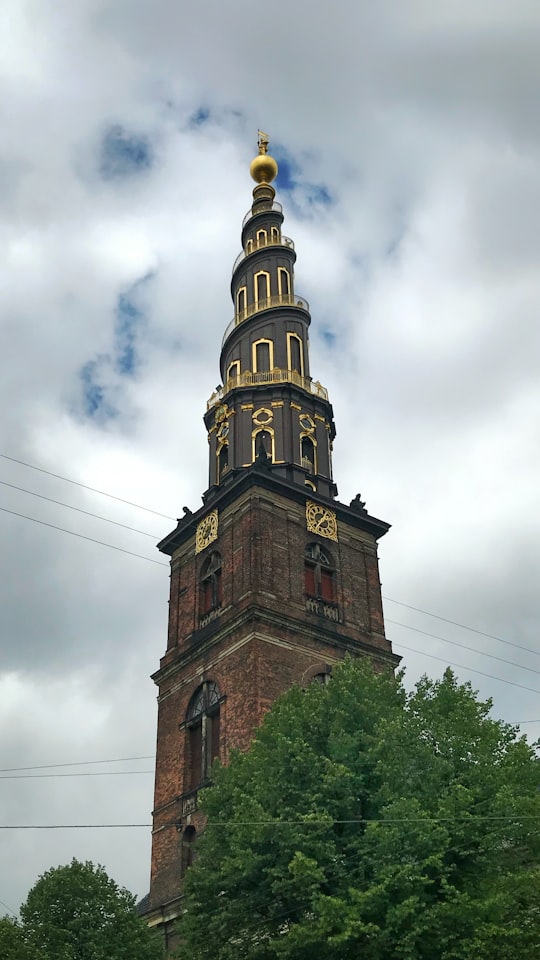 brown and gold tower near trees in Church of Our Saviour Denmark
