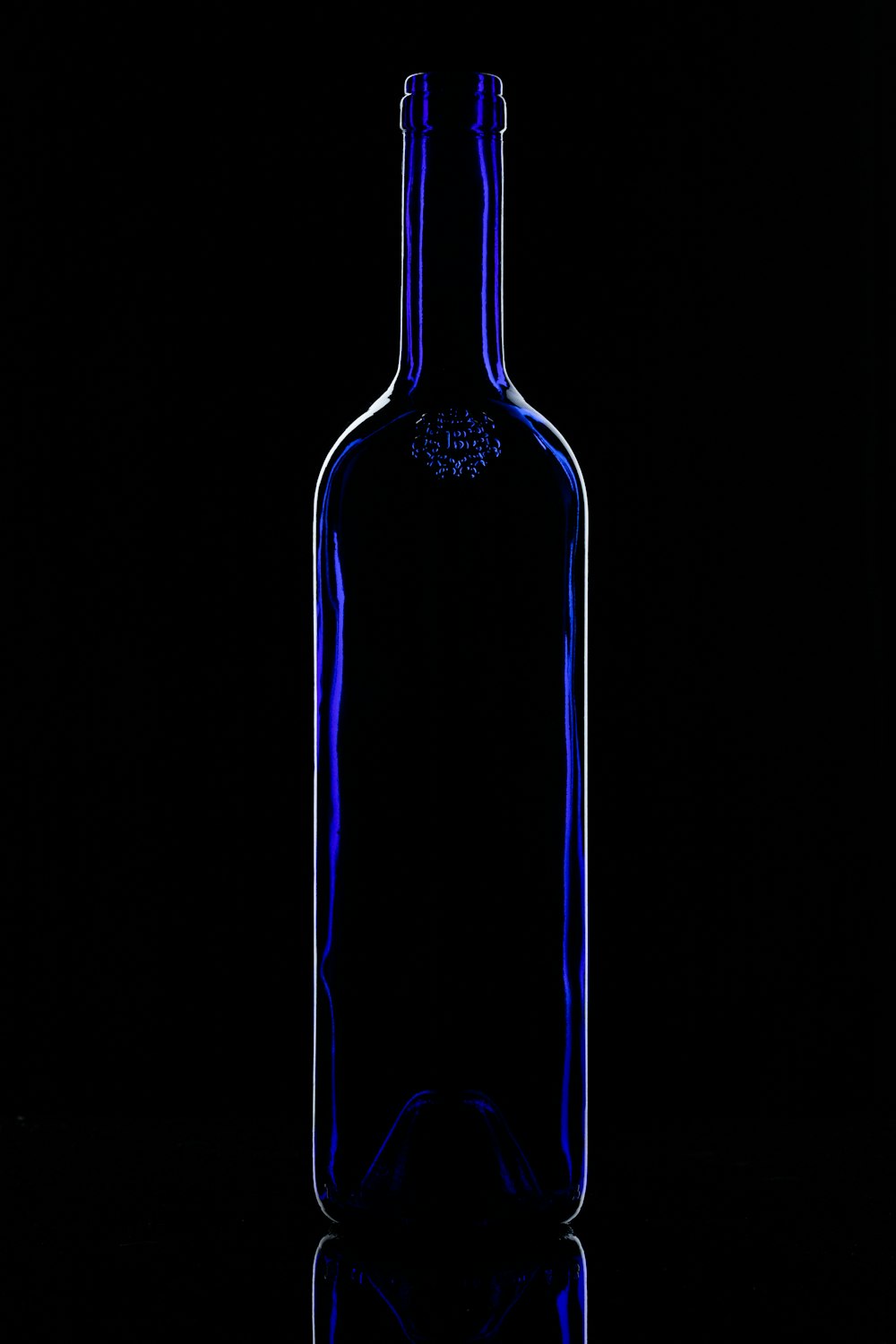 eine blaue Glasflasche, die auf einem Tisch sitzt