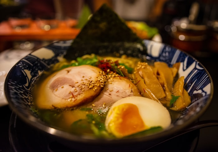 Rich tonkotsu ramen bowl with chashu pork, soft egg, and nori in a steaming broth