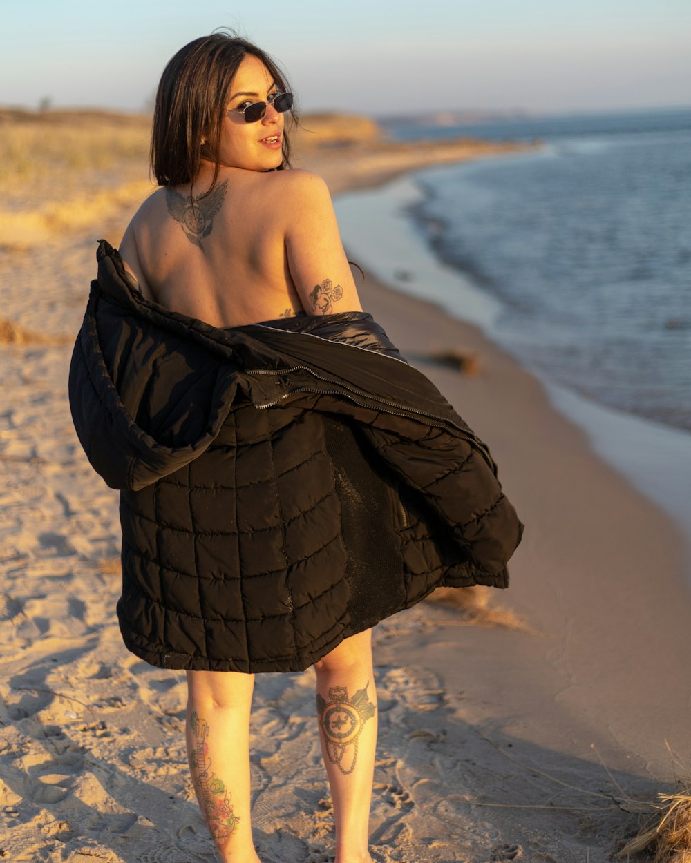 shallow focus photo of woman in black top standing on seashore