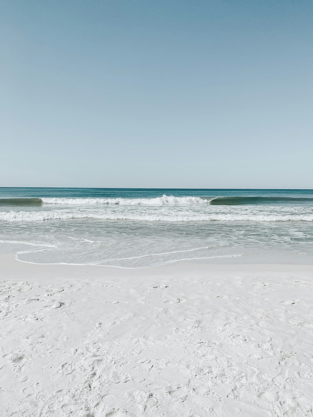 praia de areia branca sob o céu azul claro