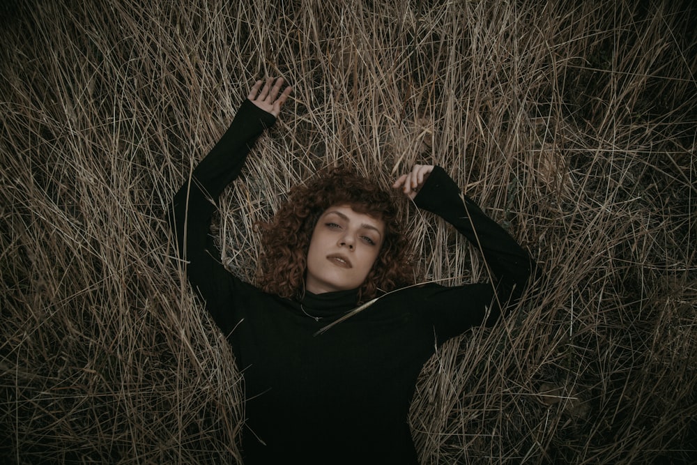 woman in black long-sleeved shirt lying on grassy field