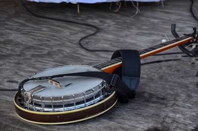 A beautifully worn banjo resting against a music stand.