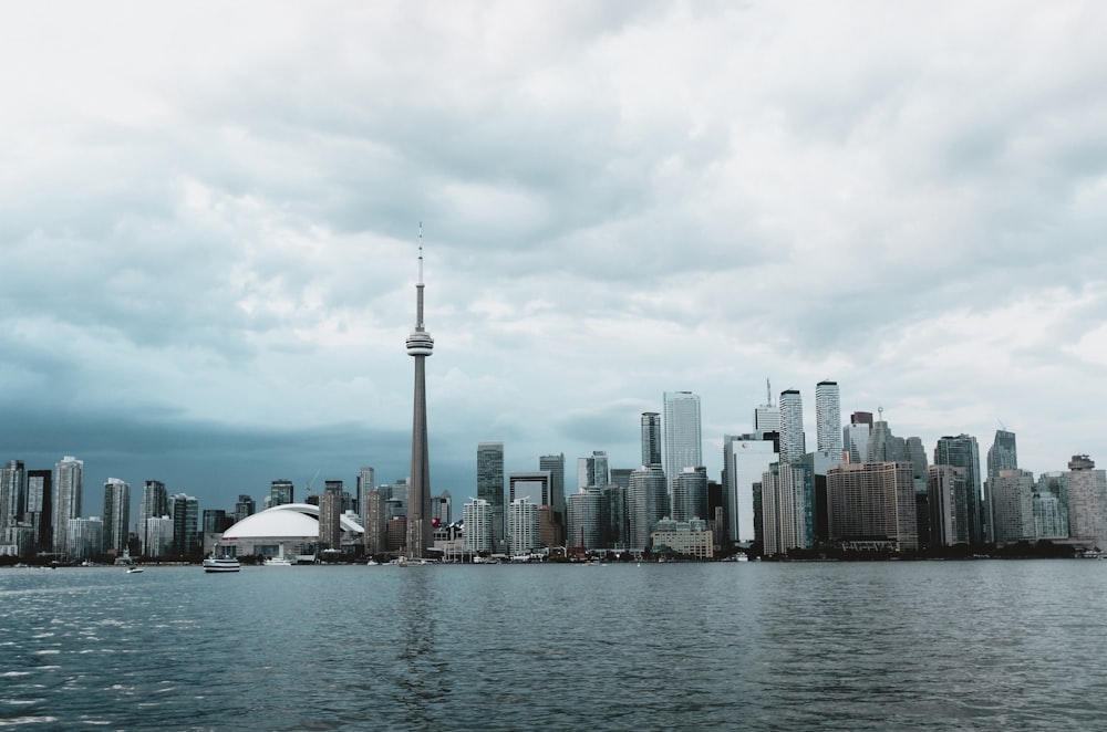 city buildings near body of water under cloudy sky during daytime