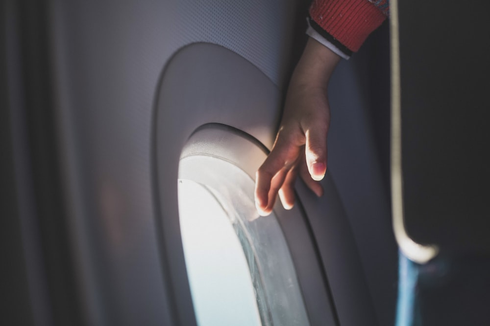 person touching airplane window