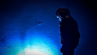 a person standing in front of a blue light