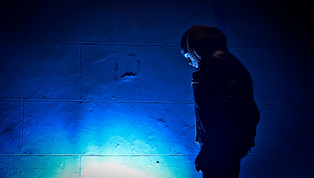 a person standing in front of a blue light