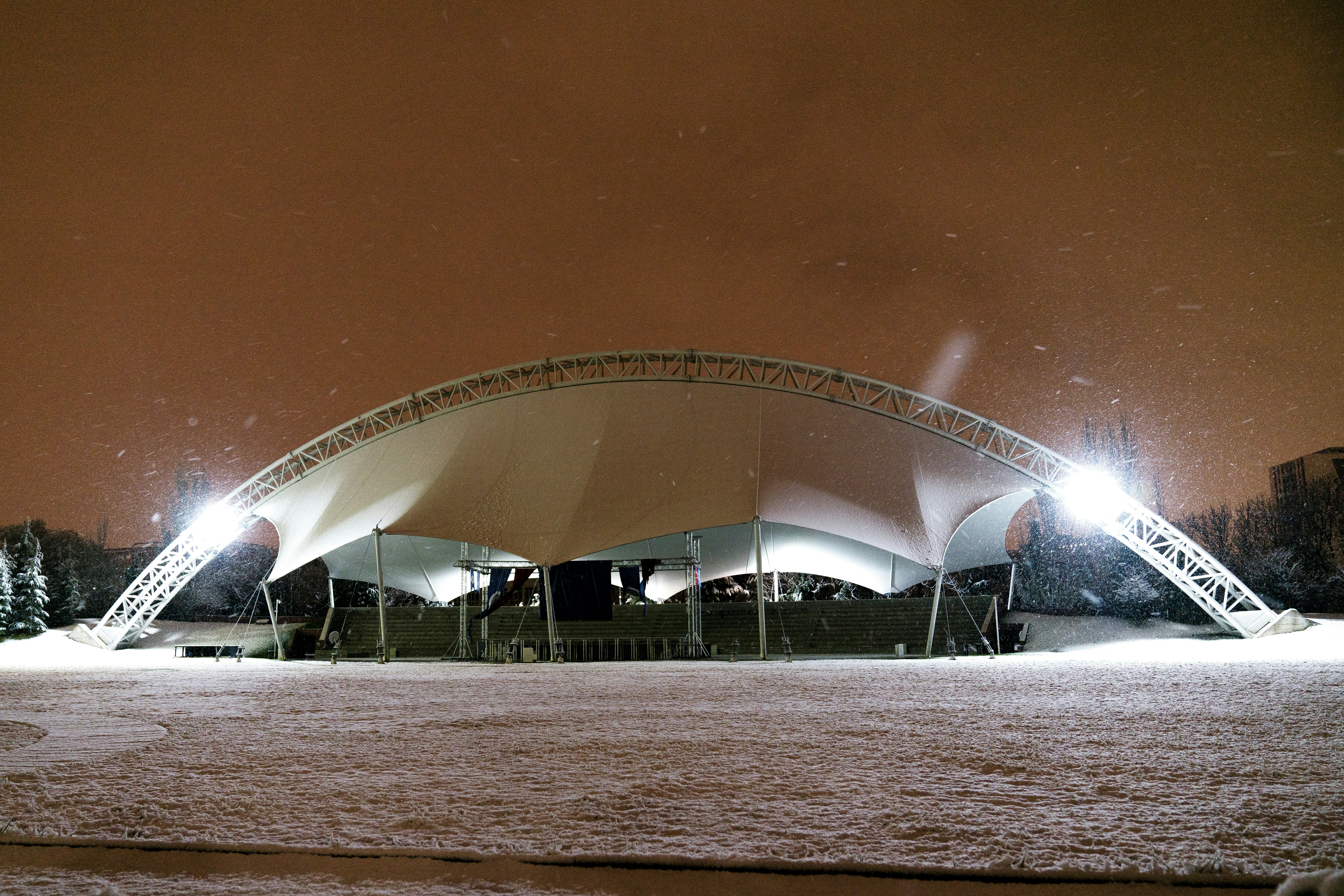 Konsertpublikum i vinteratmosfære som nyter levende musikk utendørs med snø og lys
