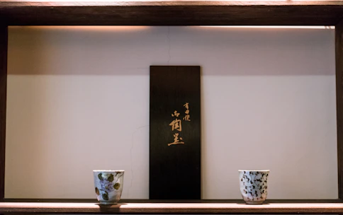 A serene display of zen-inspired ceramic ornaments arranged on a wooden shelf.