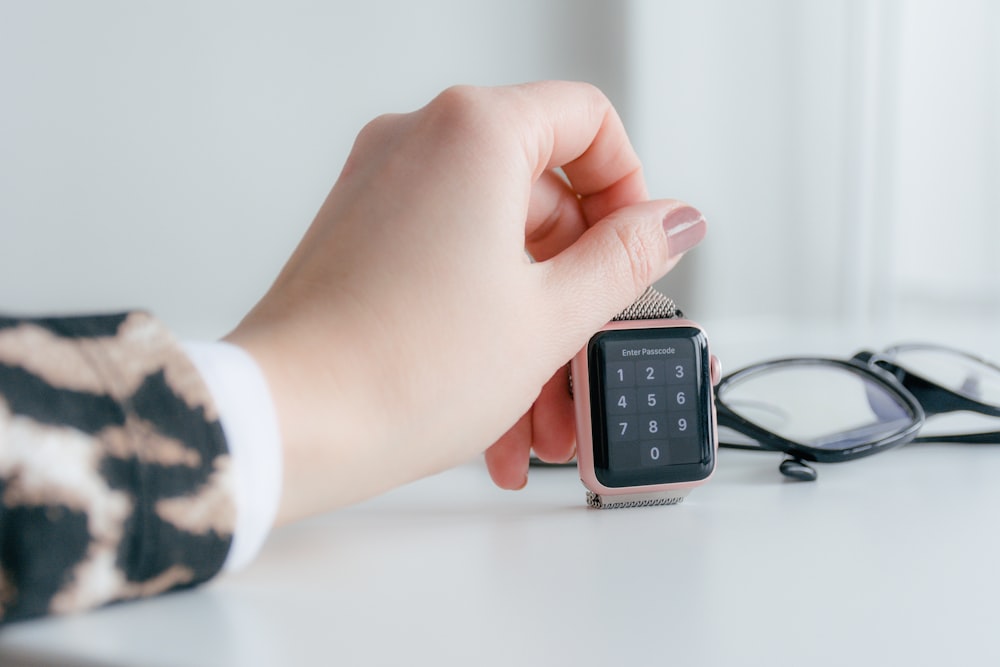 person holding gold-colored smartwatch