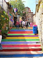 people walking climbing on multicolored stairs