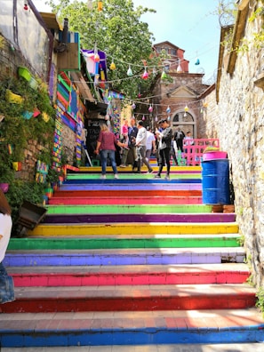people walking climbing on multicolored stairs