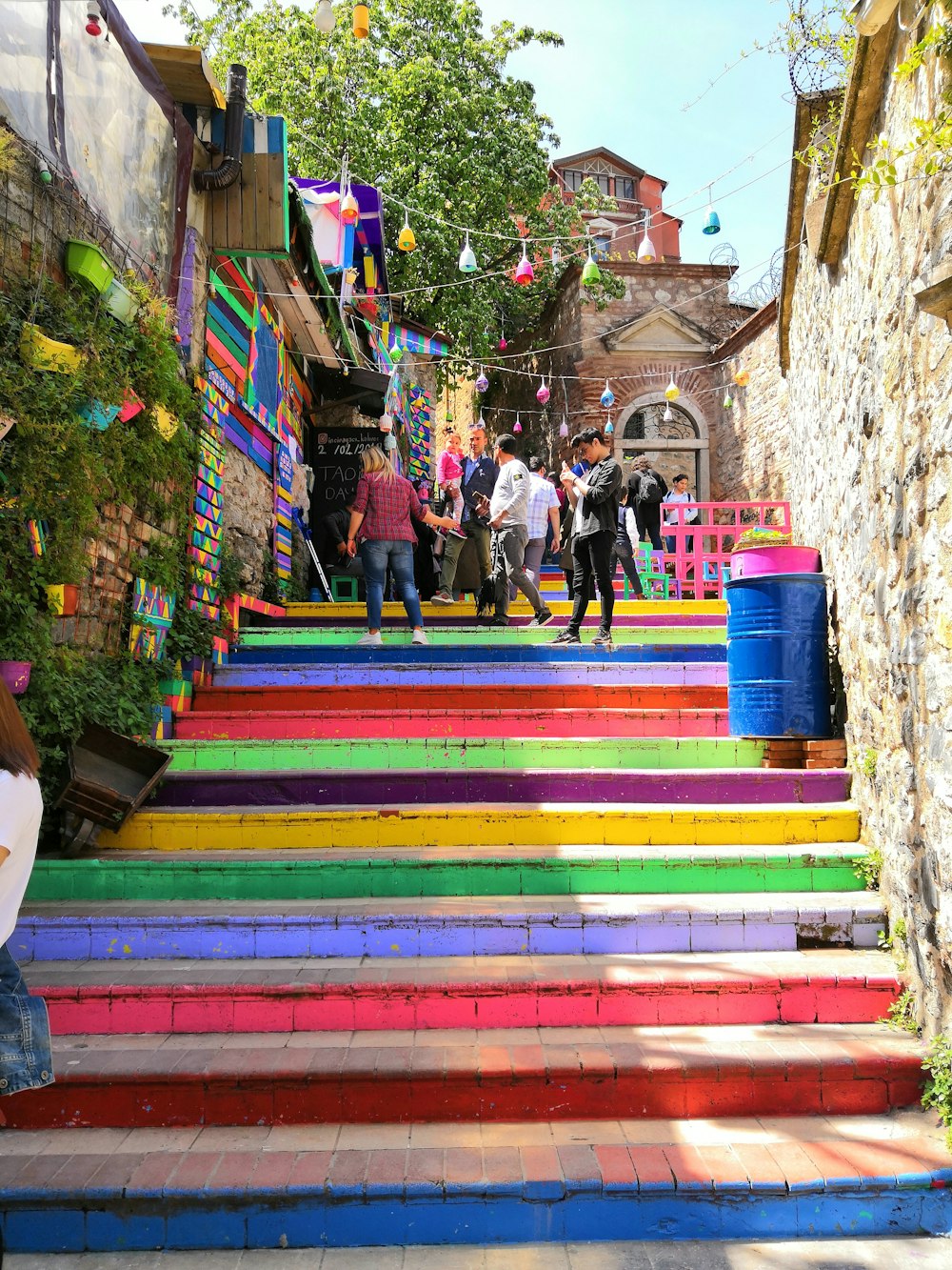 pessoas andando subindo em escadas multicoloridas