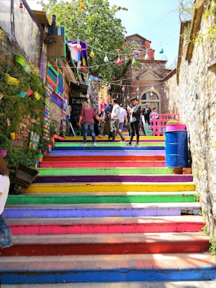 people walking climbing on multicolored stairs