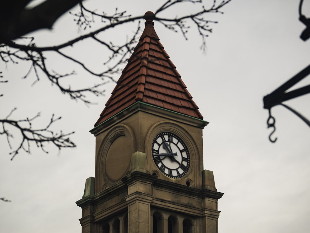 brown and red clock tower displaying 10:43 time