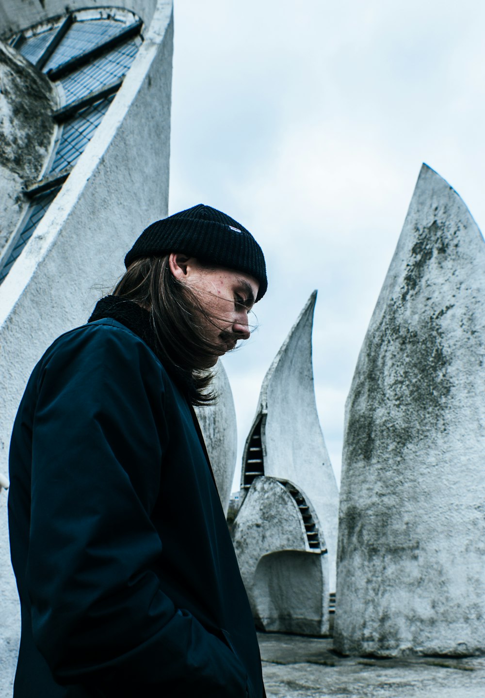 man standing and looking down near concrete wall