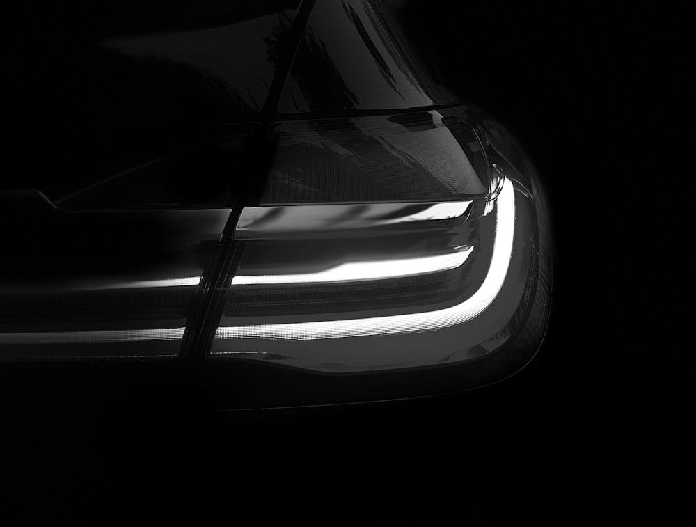um close up dos faróis de um carro no escuro