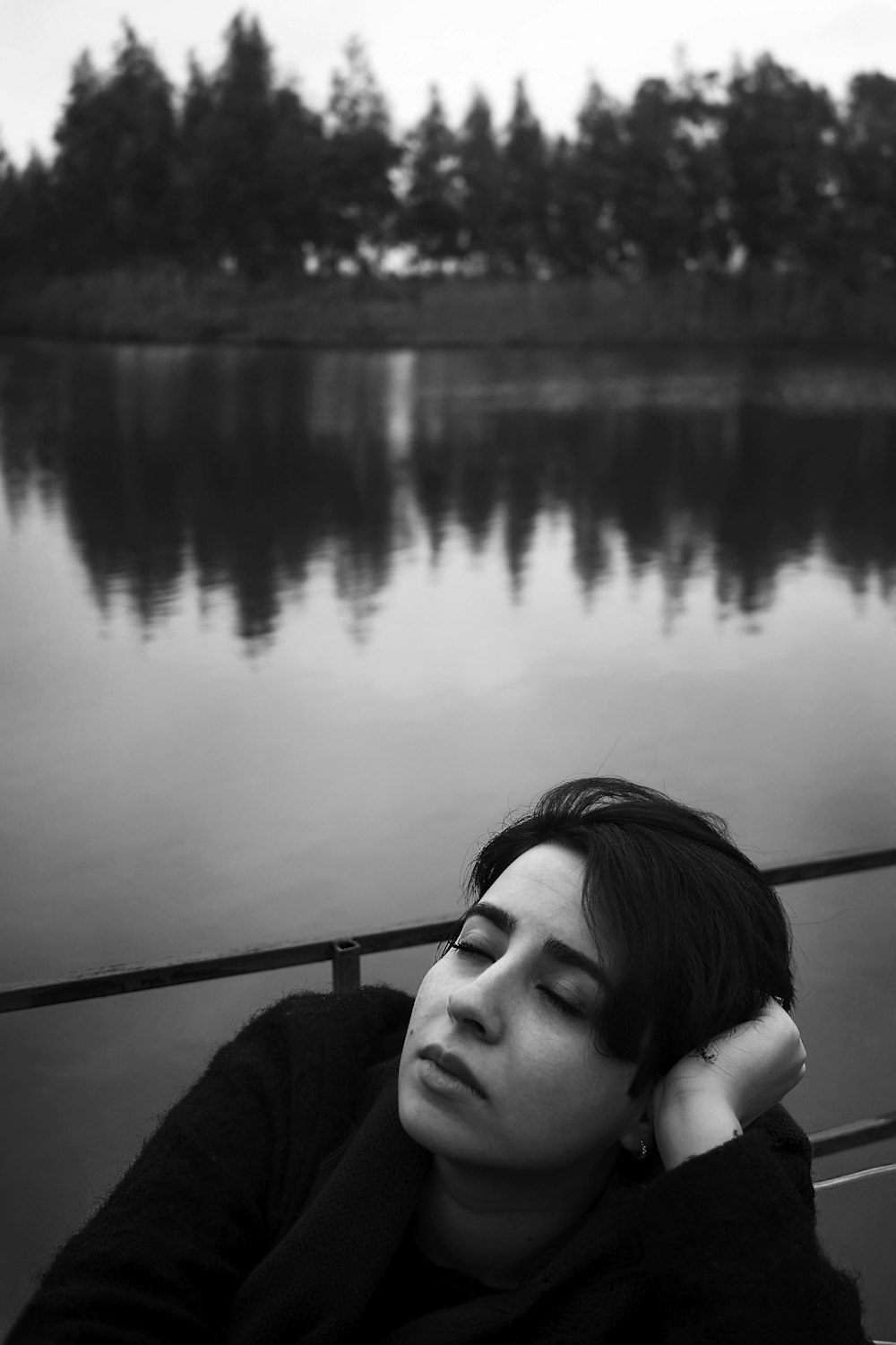 grayscale photography of person near body of water