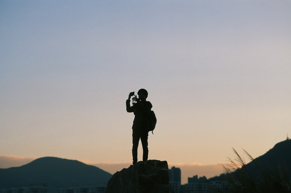 silhouette of people standing on peak