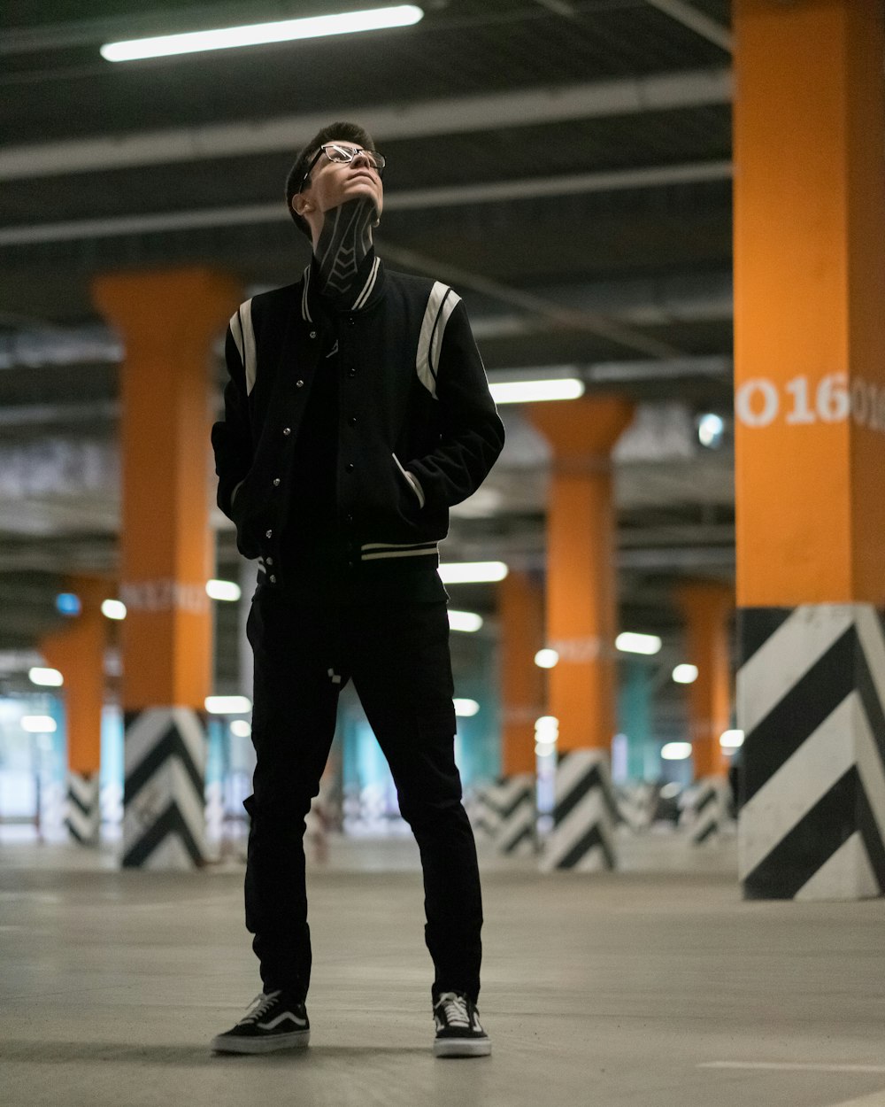 man in black and white letterman jacket looking upwards