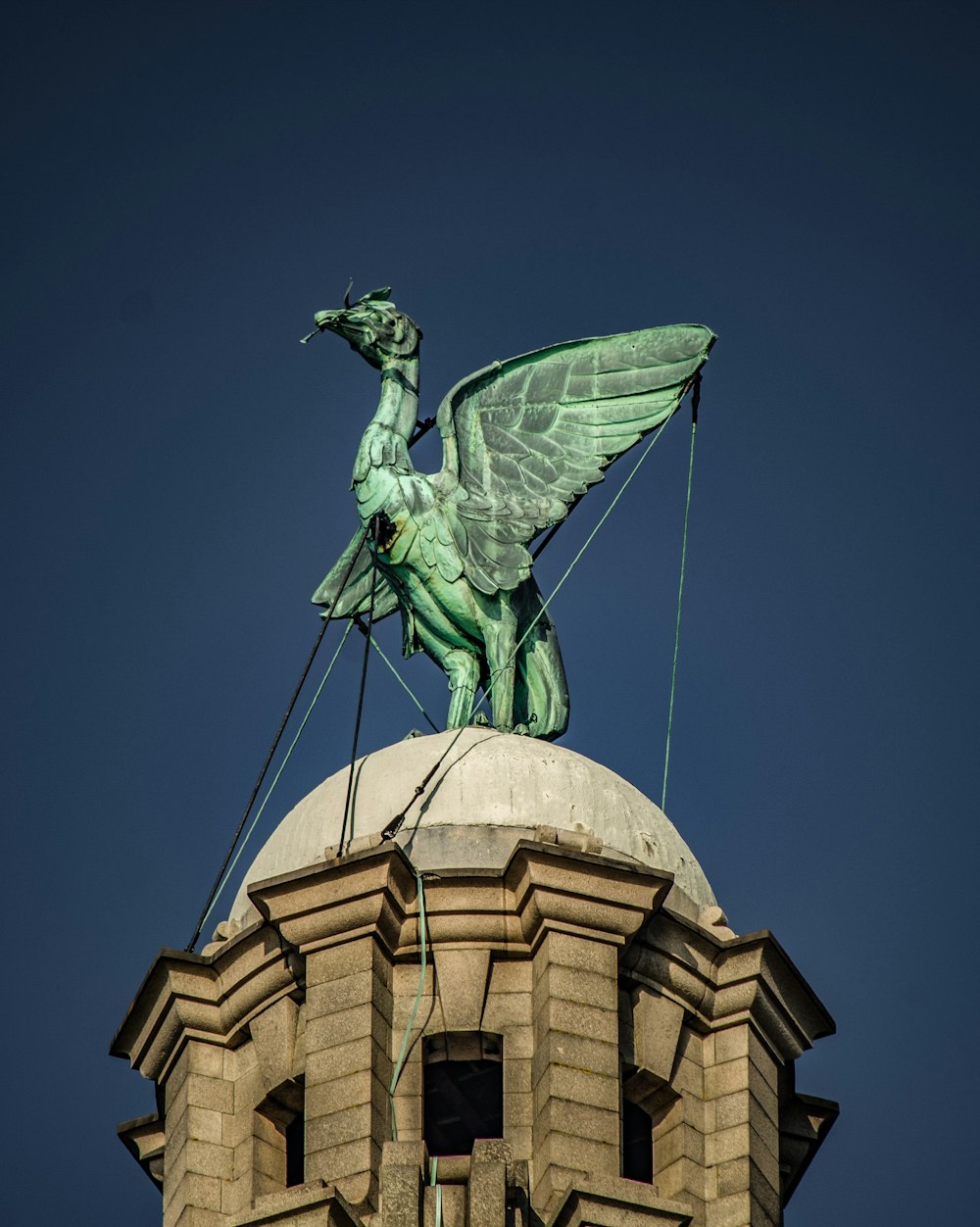 Estatua del pájaro verde sobre el templo