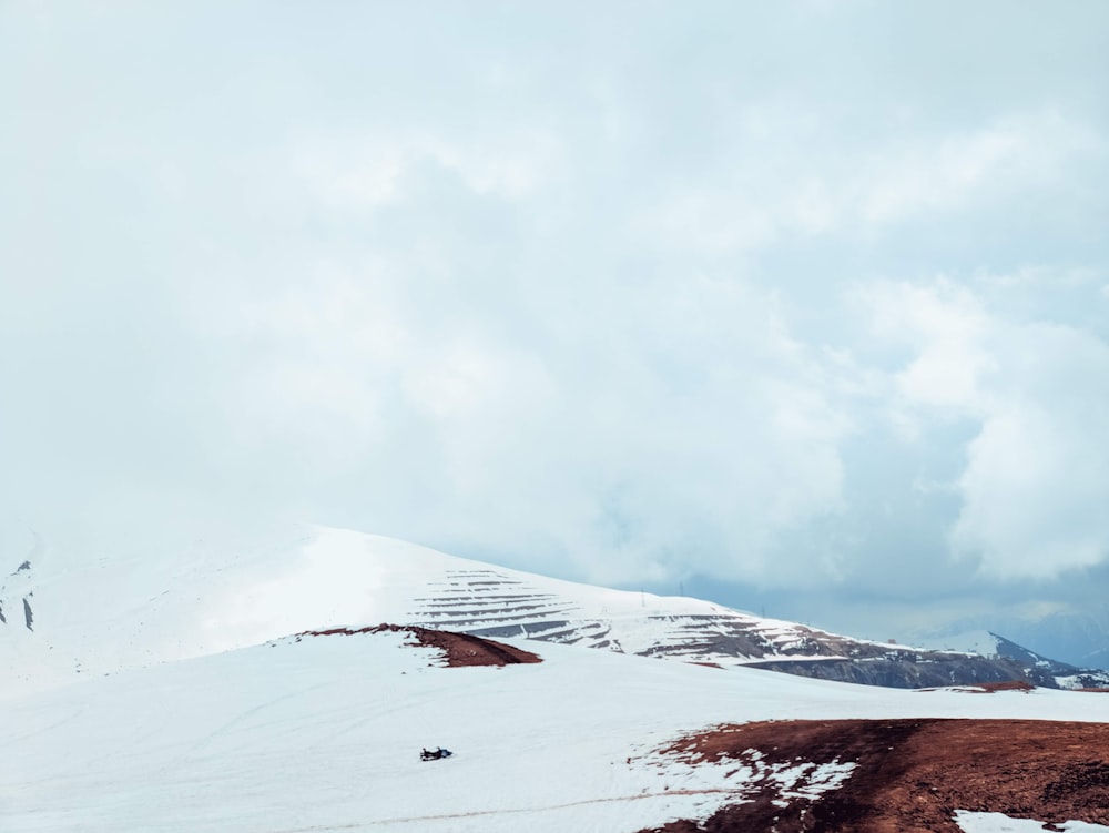 mountain covered with snow under blue and white skies