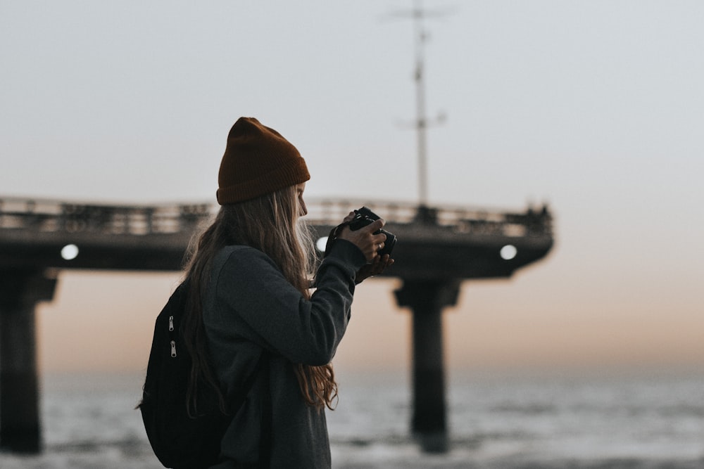 woman holding black DSLR camera