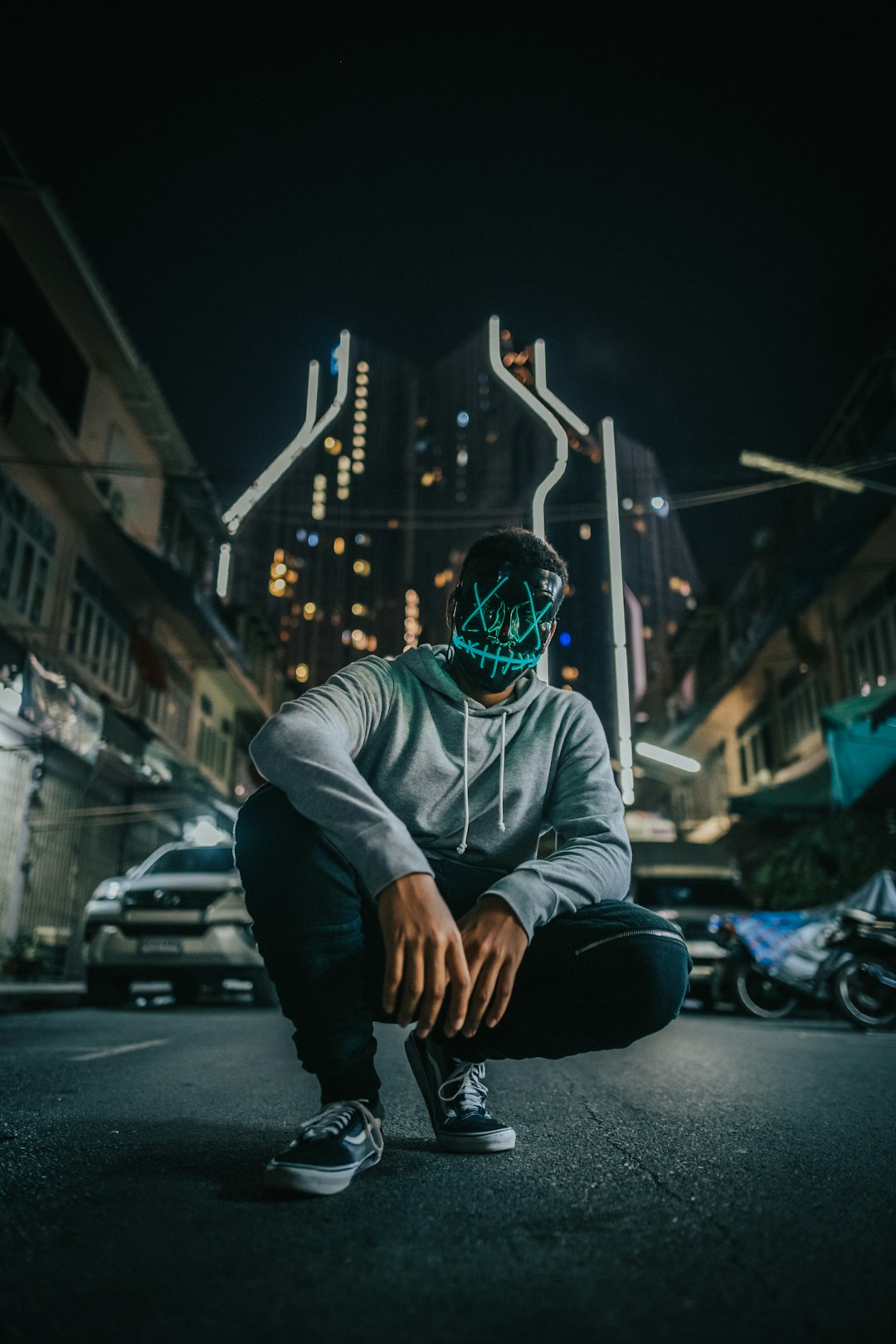 man in grey hoodie wearing black and green mask