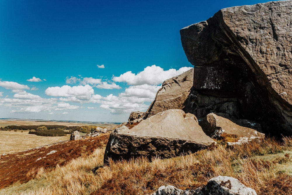 boulders on hill under blue sky