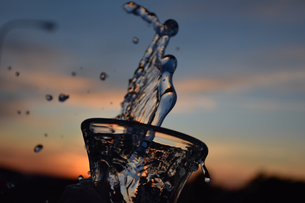 water from clear round glass splashes