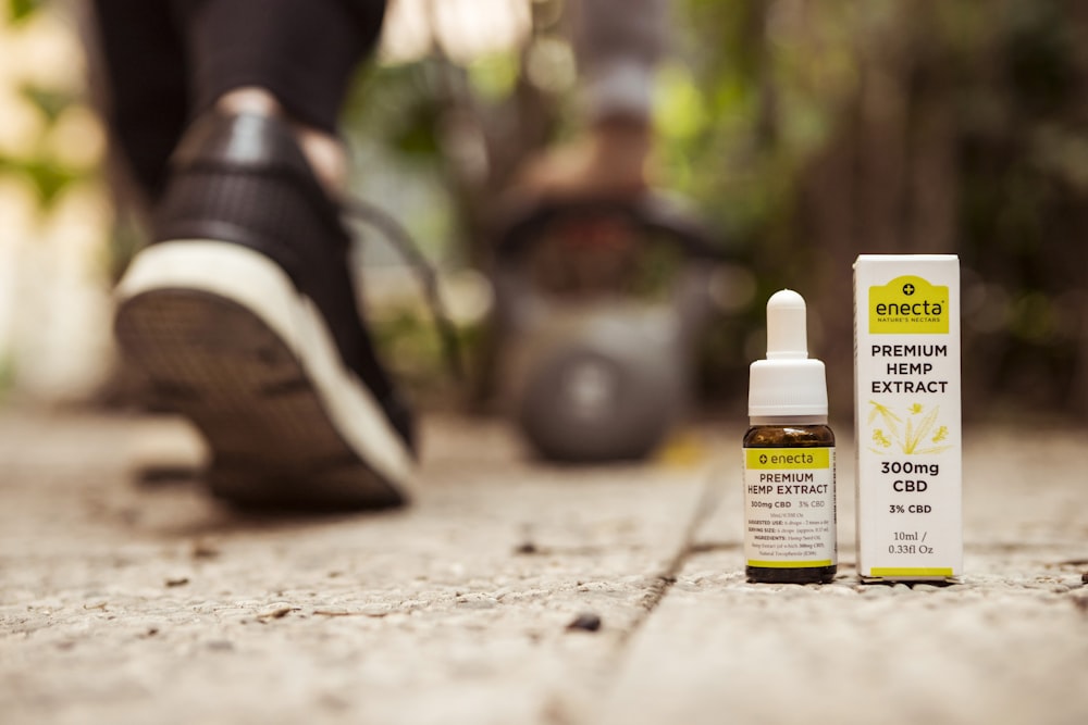 white labeled bottle near box on ground