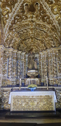 A beautifully decorated wedding altar with soft gold accents and delicate floral arrangements.